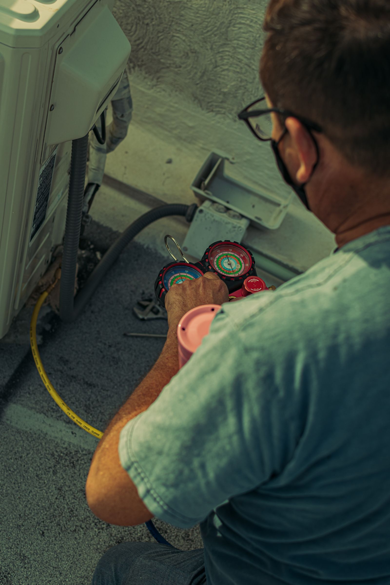Técnico limpiando la unidad condensadora de un aire acondicionado residencial